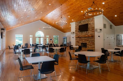 Bright dining area with round tables and chairs.