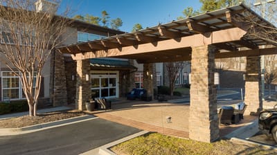 Covered entrance with seating and landscaping