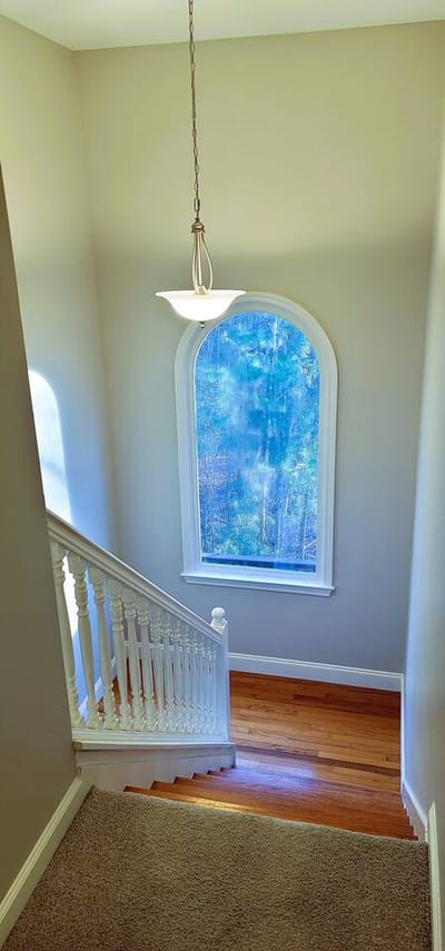 Staircase hallway with window and light fixture