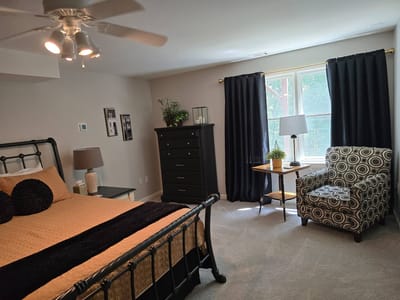 Cozy bedroom with a bed, chair, and natural light