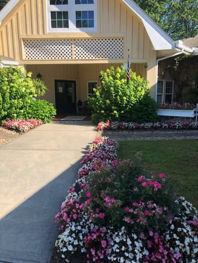 Entrance pathway with colorful flowers and building facade.