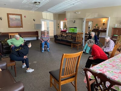 Residents participating in a group exercise activity indoors.