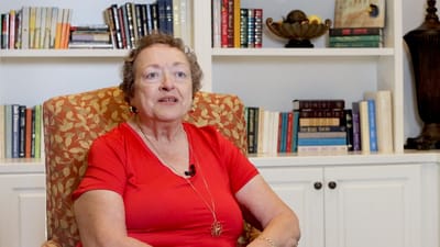 Senior woman in a vibrant top sitting in a cozy chair