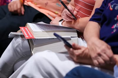 Hands holding a book and taking notes