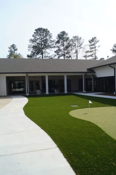 Outdoor space with greenery and putting green.