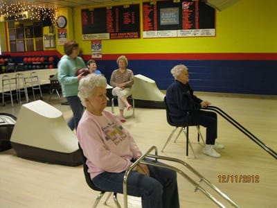 Residents participating in a bowling activity indoors.
