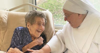 An older woman and a caregiver sharing a joyful moment.