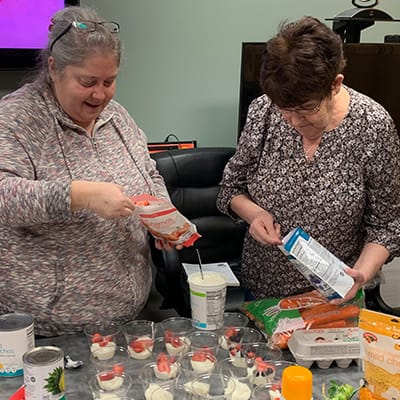 Residents preparing food together in a common area.