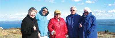 Group of happy seniors outdoors with scenic backdrop.