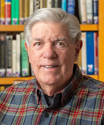 Smiling senior man in front of bookshelves