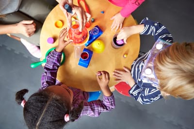 Children engaged in creative play activities at a table.