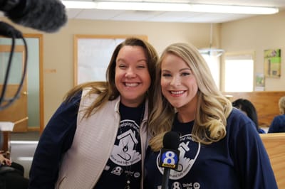 Two staff members smiling in a common area