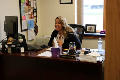 Staff member smiling at a desk in an office