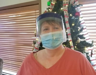 Staff member wearing a mask and face shield.