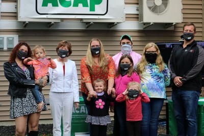 Group of people outdoors celebrating with branded signs.