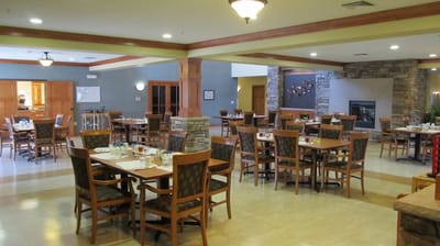 Bright dining room with tables and chairs set for meals.