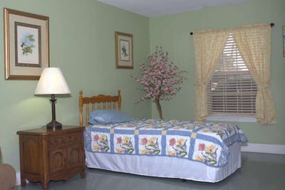 A cozy bedroom with a floral quilt and decorative elements.