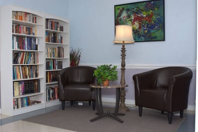 Cozy seating area with bookshelves and artwork.