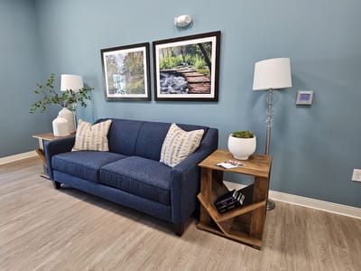Comfortable seating area with blue couch and artwork.