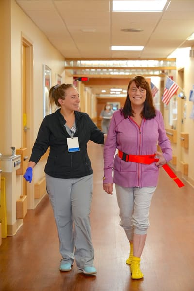 Staff assisting a resident in a hallway