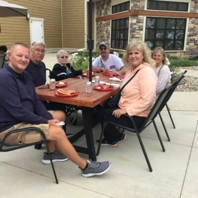 Residents enjoying an outdoor gathering at a table.