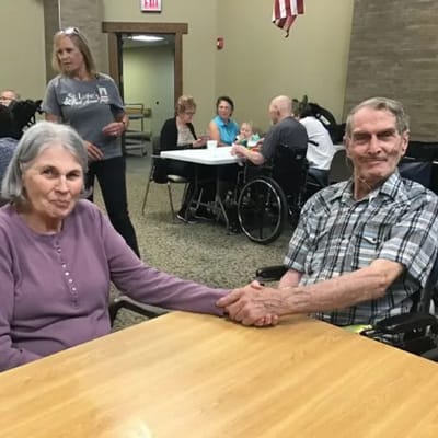 Two residents holding hands in a common area