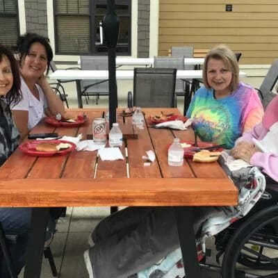 Residents and staff enjoying food outside together.