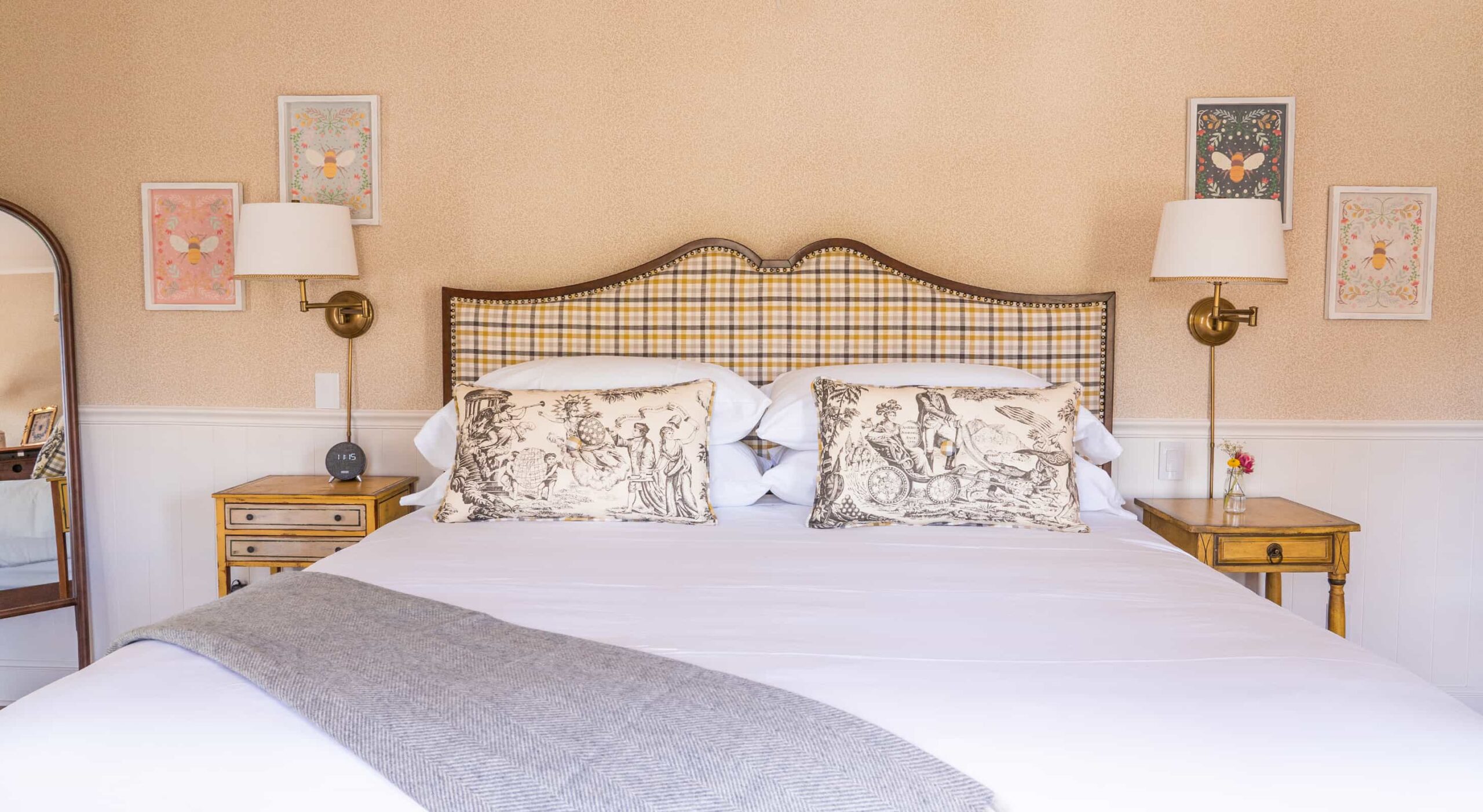 Cozy bedroom with decorative pillows and artwork.