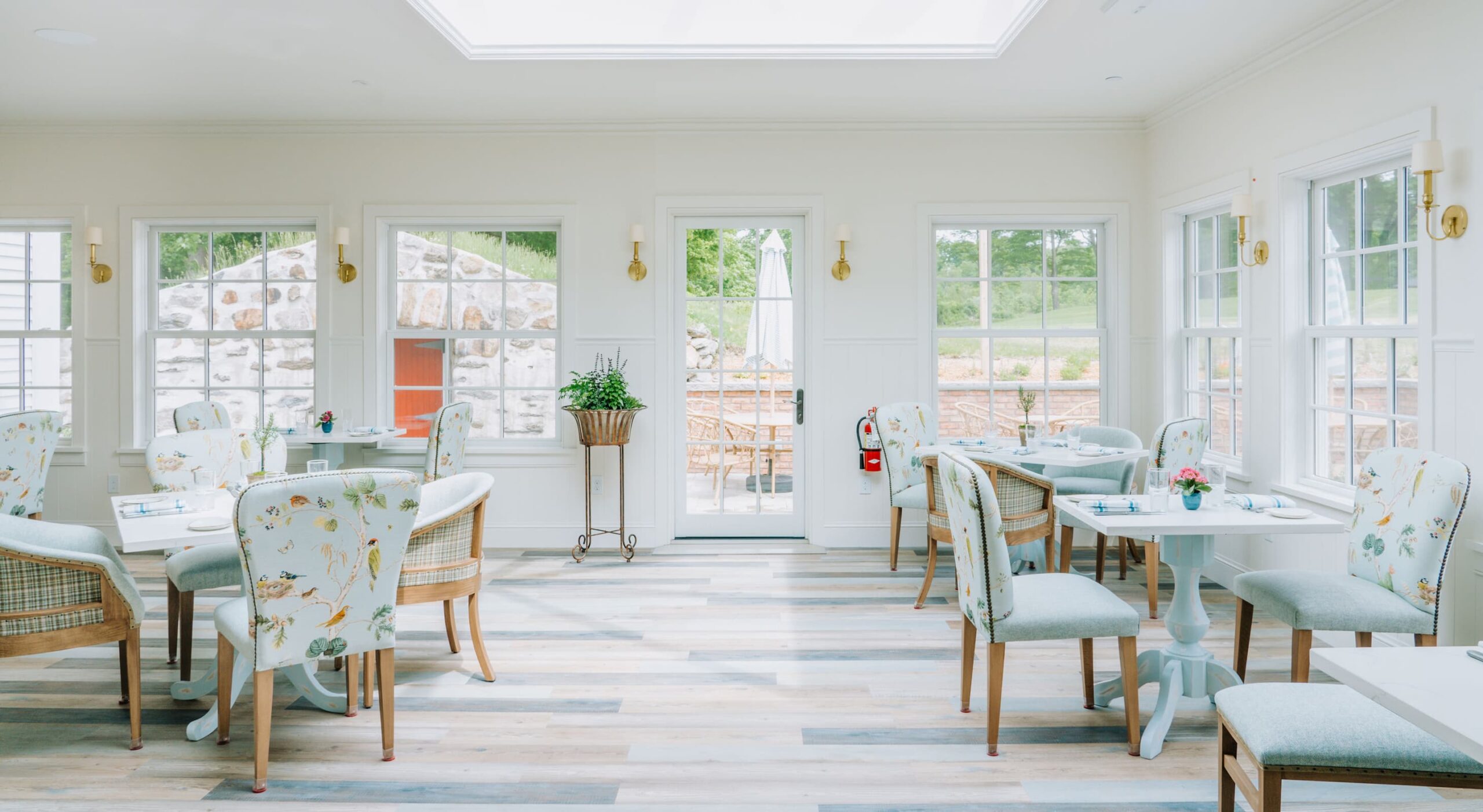 Bright dining area with floral chairs and outdoor view