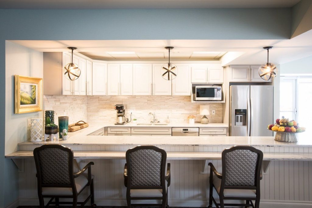 Modern kitchen with a fruit centerpiece and seating.