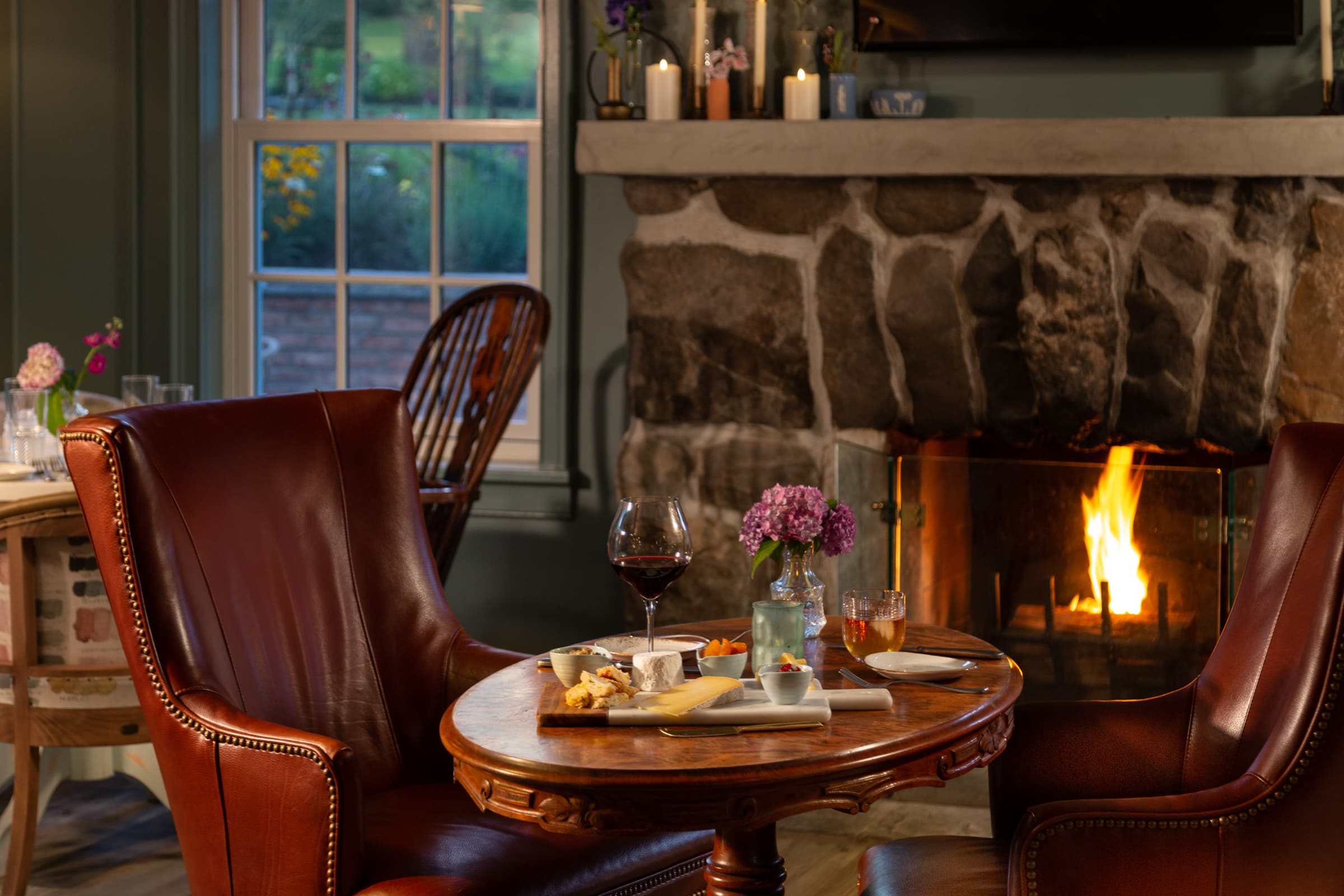 Cozy dining setting with wine and snacks by the fireplace