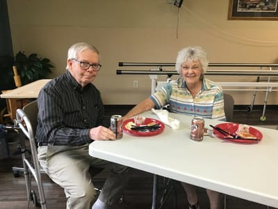 Two residents enjoying lunch at a table.