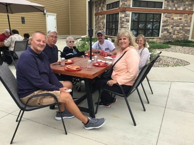 Residents enjoying time outdoors at a communal table.