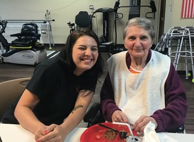 Staff member and resident enjoying a meal together.