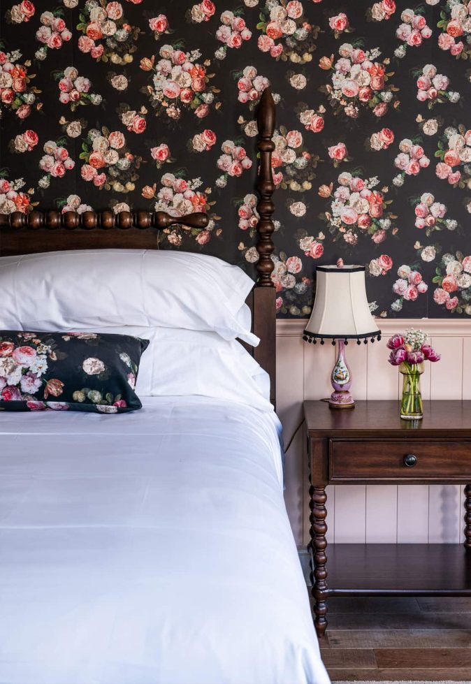 Cozy bedroom with floral wallpaper and bedside table