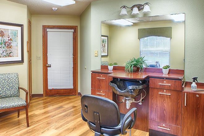 Hair salon area with styling station and chair.