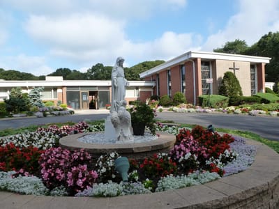 Exterior view of facility with flowers and statue