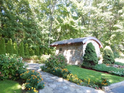 Stone structure surrounded by flowers and greenery