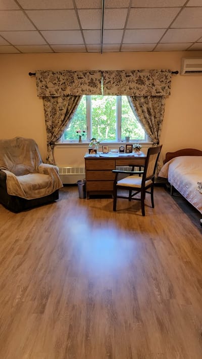 Cozy resident room with a chair and window.