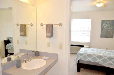 Bright bedroom and bathroom in assisted living unit.