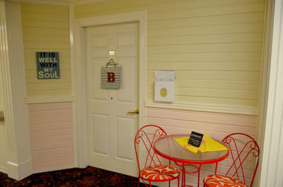 Decorative hallway with seating and wall art.