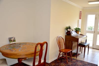 Interior common area with a puzzle table and piano.