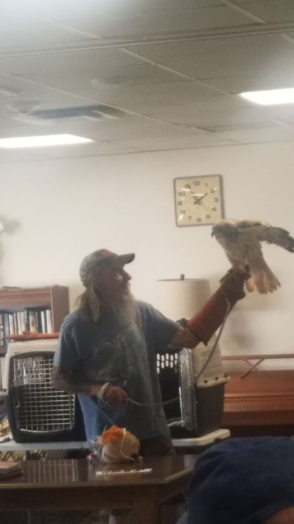 Resident interacting with a falcon indoors.