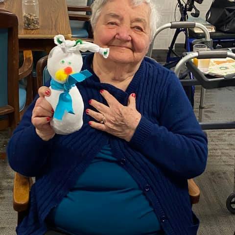 Resident holding a handmade snowman craft.