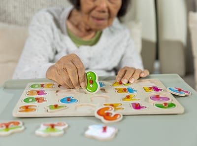 Senior woman engaging with a colorful puzzle.