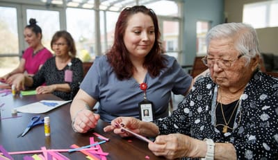 Residents and staff engaged in a craft activity