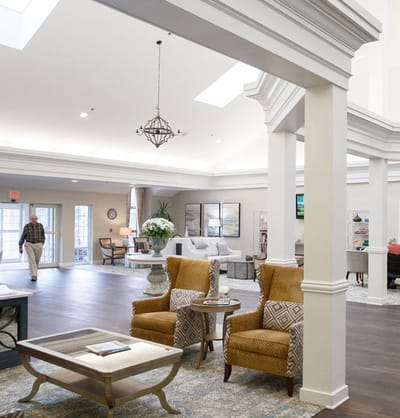Bright common area with seating and a resident.