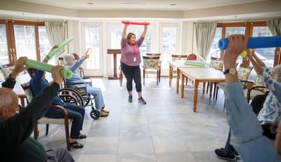 Residents participating in a fitness activity with a staff member.