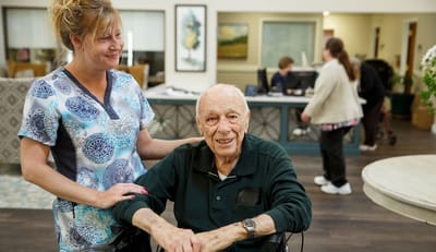 Staff and resident interacting in a common area.
