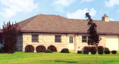 Exterior view of a facility building surrounded by grass.